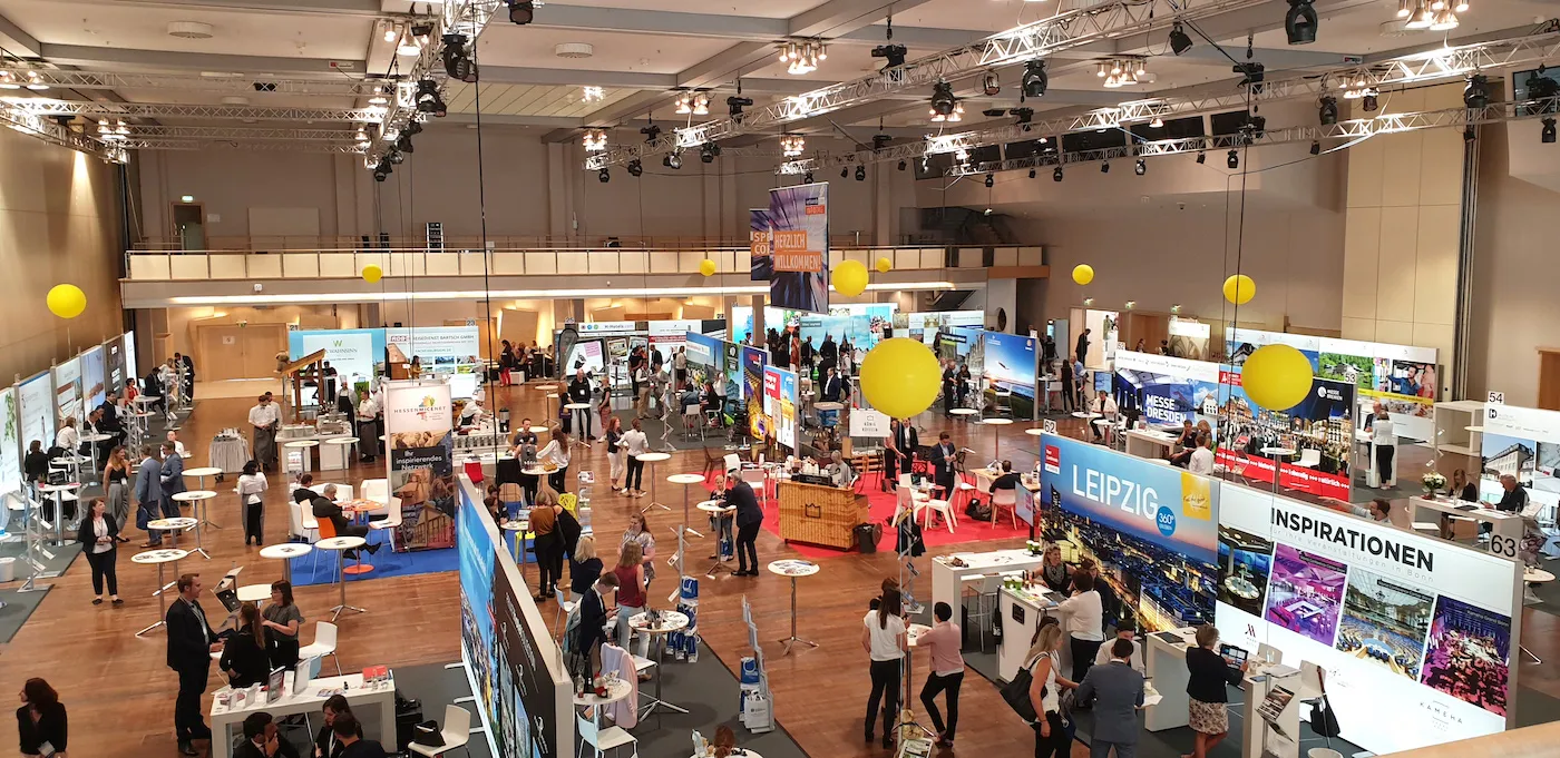Blick auf eine Messe, bei welcher die Rallye-Stände mit gelben Ballon markiert sind.